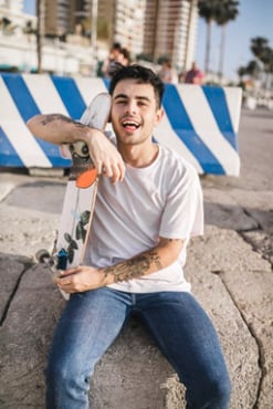 Un joven mexicano sosteniendo su patineta.
